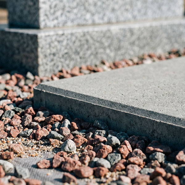 Стык тротуарной плитки и цветного щебня – пример бюджетного благоустройства могилы.